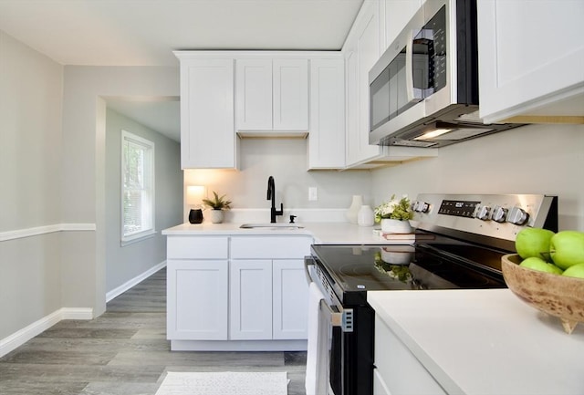 100 Haskin St, Springfield, MA 01109 - kitchen with appliances with stainless steel finishes, white cabinetry, light countertops, and light wood-type flooring