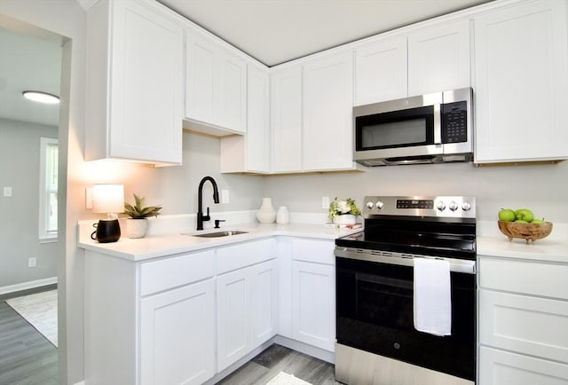 100 Haskin St, Springfield, MA 01109 - kitchen with appliances with stainless steel finishes, light countertops, light wood-style floors, and white cabinetry