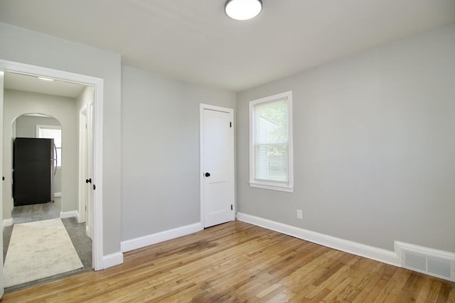 100 Haskin St, Springfield, MA 01109 - unfurnished bedroom featuring freestanding refrigerator, arched walkways, light wood-type flooring, and a closet