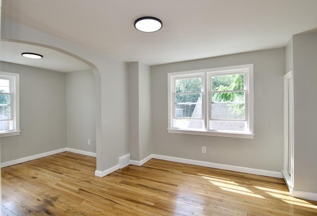 100 Haskin St, Springfield, MA 01109 - empty room featuring healthy amount of natural light, arched walkways, and light wood-style flooring