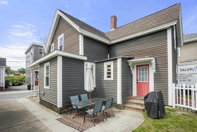 24 Everett St, Woburn, MA 01801 - back of house featuring a chimney, roof with shingles, and a patio