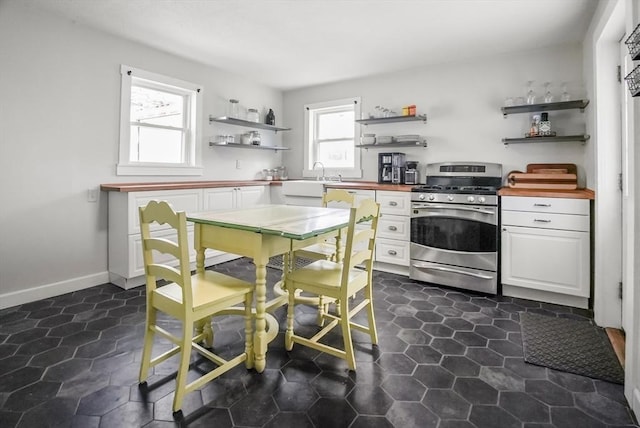 24 Everett St, Woburn, MA 01801 - kitchen featuring open shelves, gas stove, white cabinets, wood counters, and a sink
