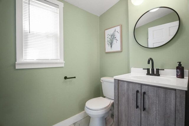 24 Everett St, Woburn, MA 01801 - half bathroom with baseboards, toilet, and vanity