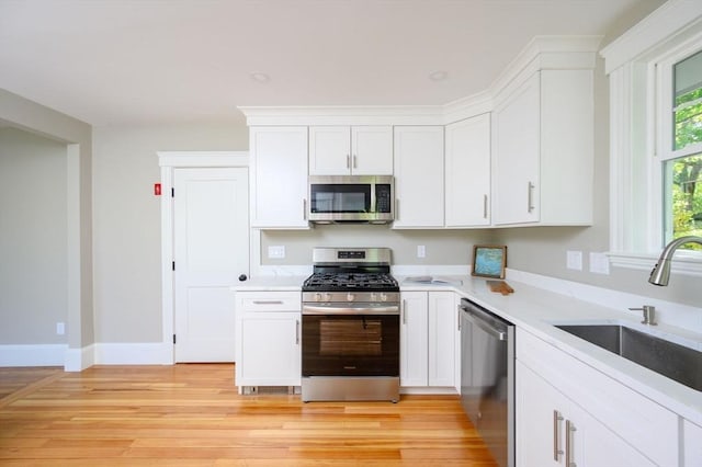 9 School St, Hull, MA 02045 - kitchen featuring light countertops, white cabinetry, appliances with stainless steel finishes, and a sink