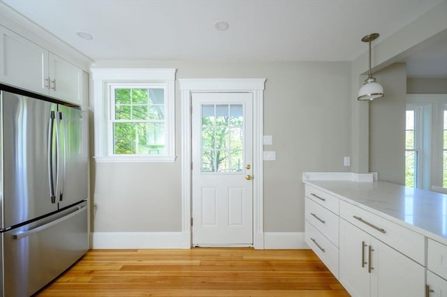 9 School St, Hull, MA 02045 - kitchen with white cabinets, light wood finished floors, freestanding refrigerator, baseboards, and pendant lighting