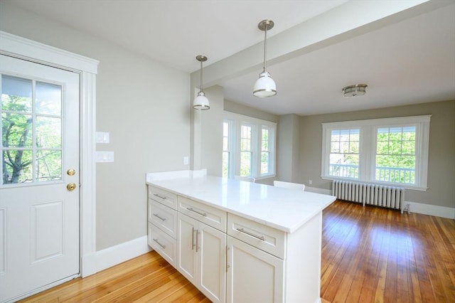 9 School St, Hull, MA 02045 - kitchen featuring plenty of natural light, radiator, a peninsula, and white cabinets