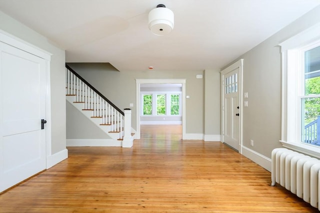 9 School St, Hull, MA 02045 - entryway with radiator heating unit, baseboards, light wood finished floors, and stairs