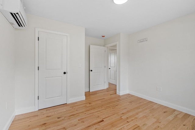7 S Porter St Unit 7, Haverhill, MA 01835 - unfurnished bedroom featuring a wall mounted AC and light wood-style floors