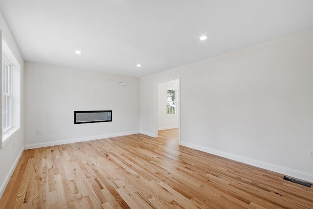 7 S Porter St Unit 7, Haverhill, MA 01835 - unfurnished living room featuring light wood-style floors, a glass covered fireplace, and recessed lighting