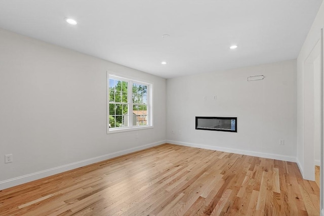 7 S Porter St Unit 7, Haverhill, MA 01835 - unfurnished living room with light wood-style floors, a glass covered fireplace, and recessed lighting