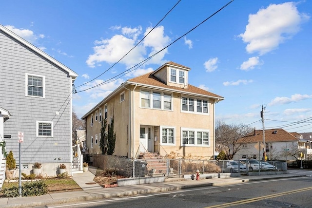 view of front of home with a fenced front yard and stucco siding