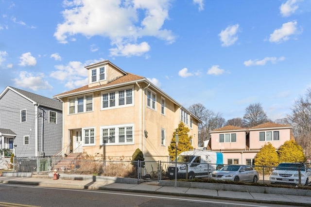 view of front facade with a fenced front yard, a residential view, stucco siding, and entry steps