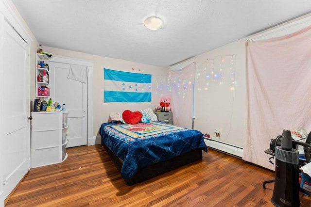 bedroom featuring a baseboard radiator and wood finished floors