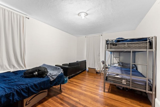 bedroom featuring a textured ceiling and wood finished floors