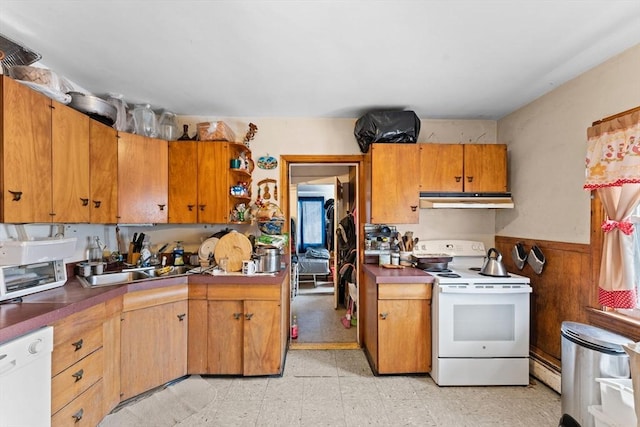 kitchen with under cabinet range hood, a wainscoted wall, light floors, white appliances, and open shelves