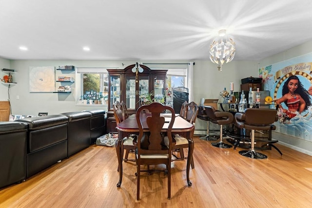 dining space with recessed lighting, plenty of natural light, an inviting chandelier, and light wood finished floors