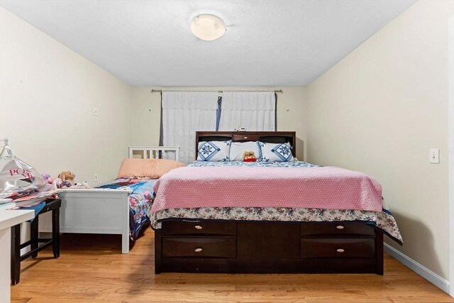 bedroom featuring light wood-type flooring and baseboards