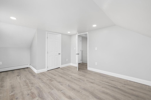 additional living space featuring recessed lighting, wood finished floors, lofted ceiling, a baseboard heating unit, and baseboards