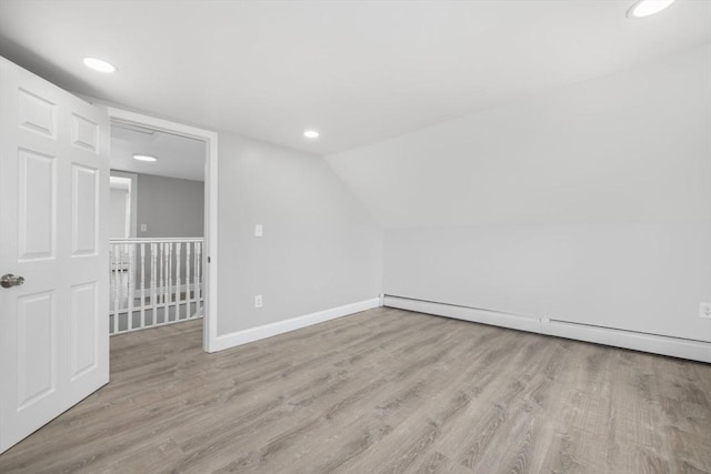 bonus room with a baseboard radiator, wood finished floors, recessed lighting, baseboards, and vaulted ceiling