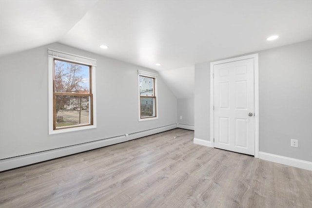 additional living space with vaulted ceiling, baseboard heating, wood finished floors, baseboards, and recessed lighting