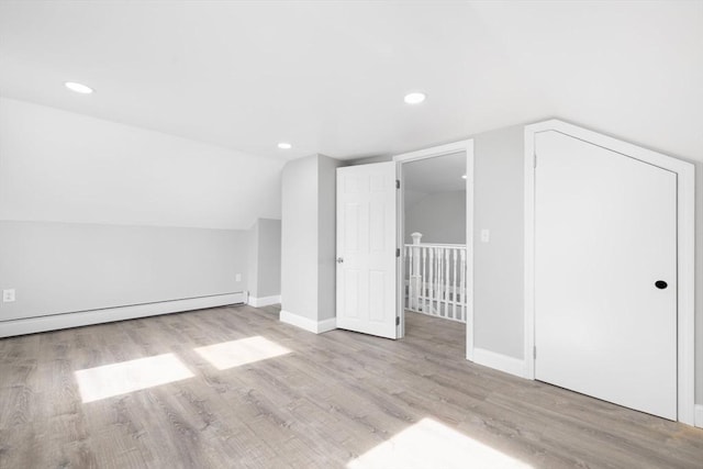 bonus room featuring wood finished floors, a baseboard radiator, recessed lighting, baseboards, and lofted ceiling