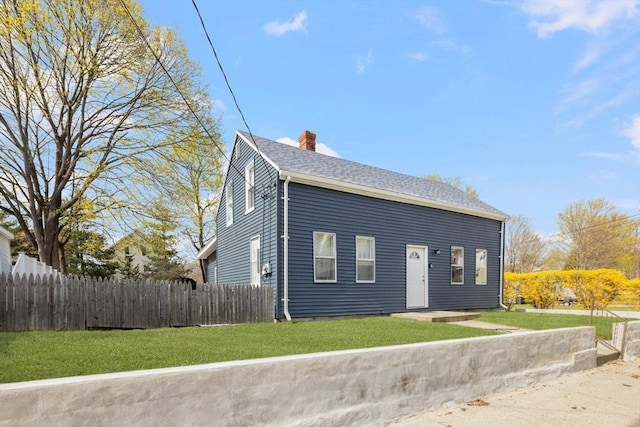 view of front facade featuring a chimney and a shingled roof