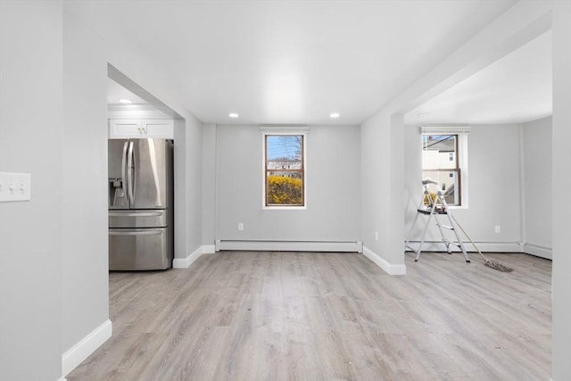 unfurnished living room featuring a baseboard radiator, plenty of natural light, light wood finished floors, baseboards, and recessed lighting