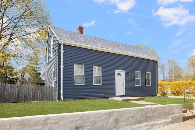 view of front of house with a chimney and roof with shingles