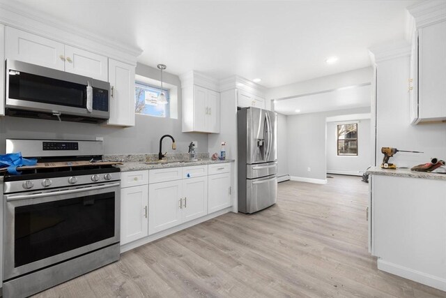 kitchen featuring stainless steel appliances, a sink, white cabinets, light wood-style flooring, and recessed lighting