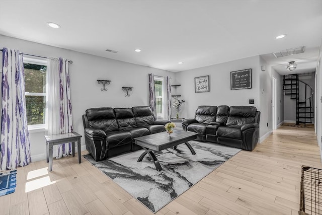 living area featuring stairway, a wealth of natural light, recessed lighting, and light wood-style flooring
