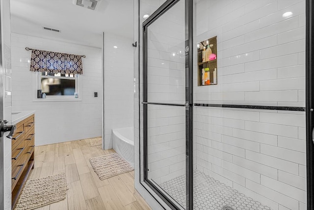 bathroom with a shower stall, visible vents, and vanity