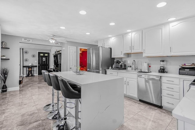 kitchen featuring a breakfast bar, appliances with stainless steel finishes, recessed lighting, and a sink
