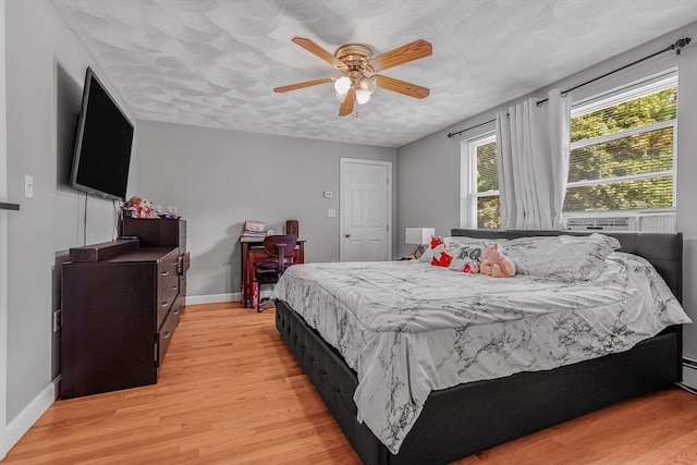 bedroom with light wood-style flooring, baseboards, and ceiling fan