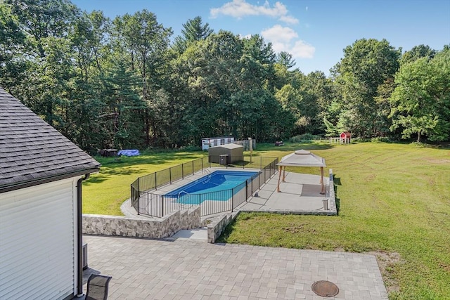 view of swimming pool featuring a yard, a fenced in pool, a patio, and fence