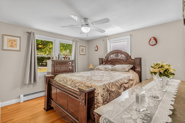 bedroom with a baseboard radiator, light wood-style flooring, a ceiling fan, and baseboards