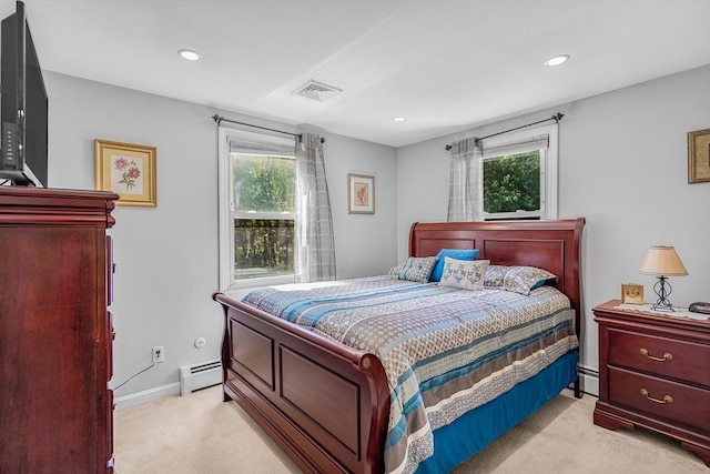 bedroom featuring a baseboard heating unit, multiple windows, and light colored carpet
