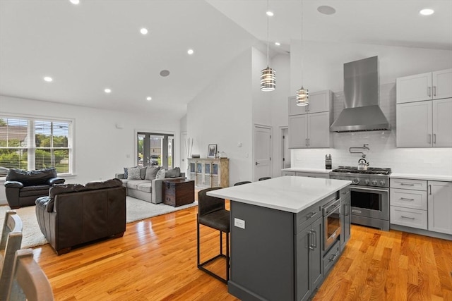 751 Sharps Lot Rd, Swansea, MA 02777 - kitchen with wall chimney range hood, appliances with stainless steel finishes, gray cabinetry, light countertops, and high vaulted ceiling