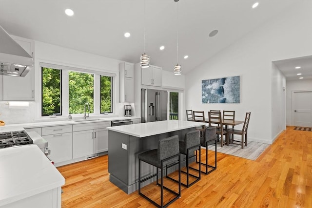 751 Sharps Lot Rd, Swansea, MA 02777 - kitchen featuring stainless steel appliances, recessed lighting, wall chimney exhaust hood, light countertops, and a breakfast bar area