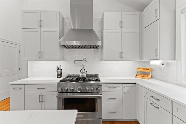 751 Sharps Lot Rd, Swansea, MA 02777 - kitchen featuring wall chimney range hood, stainless steel stove, backsplash, light countertops, and vaulted ceiling