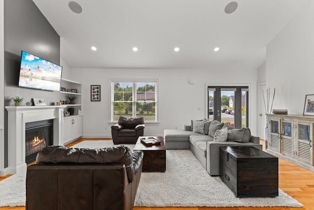 751 Sharps Lot Rd, Swansea, MA 02777 - living room featuring light wood-style flooring, a glass covered fireplace, recessed lighting, and high vaulted ceiling
