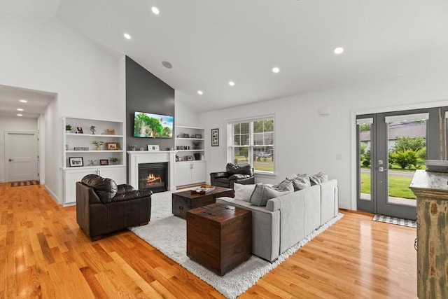 751 Sharps Lot Rd, Swansea, MA 02777 - living room with high vaulted ceiling, light wood finished floors, a glass covered fireplace, and recessed lighting