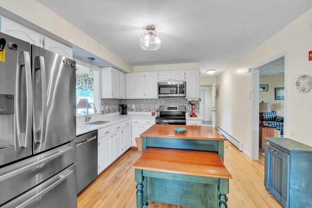 kitchen featuring a baseboard radiator, a sink, wood counters, stainless steel appliances, and light wood-type flooring