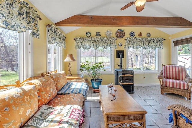 tiled living room with lofted ceiling with beams, ceiling fan, a wealth of natural light, and a wood stove