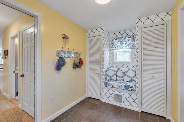 hallway featuring baseboards and visible vents