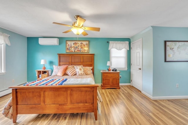 bedroom featuring light wood-style floors, baseboards, ceiling fan, and a wall mounted air conditioner