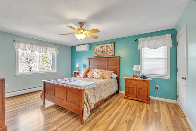 bedroom featuring ceiling fan, a wall mounted air conditioner, light wood-style flooring, baseboards, and a baseboard heating unit