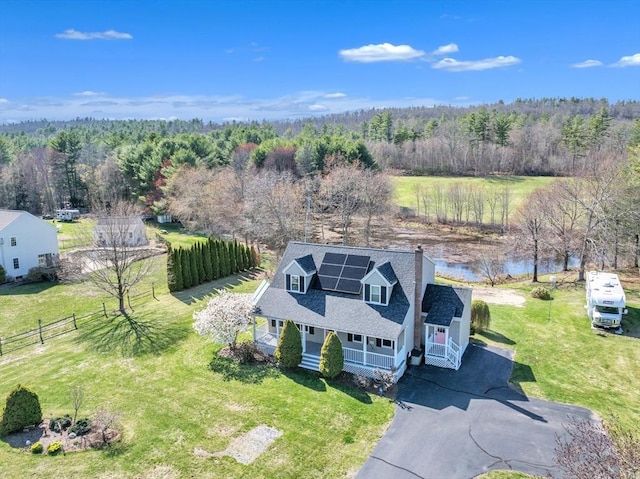 birds eye view of property with a water view and a view of trees
