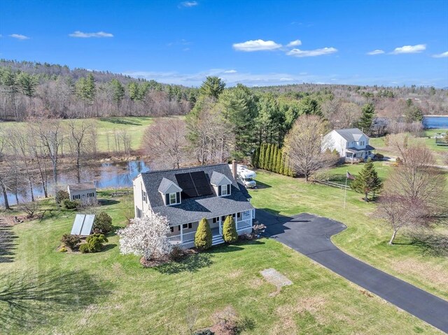 birds eye view of property with a view of trees and a water view