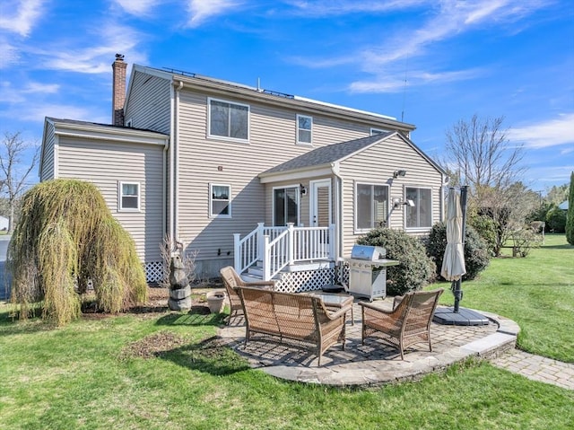 rear view of property featuring outdoor lounge area, a patio area, a yard, and a chimney