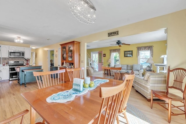 dining area with light wood finished floors and ceiling fan